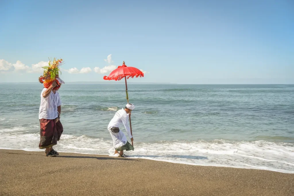 People offering prayers on the beach as a part of Melasti ceremony