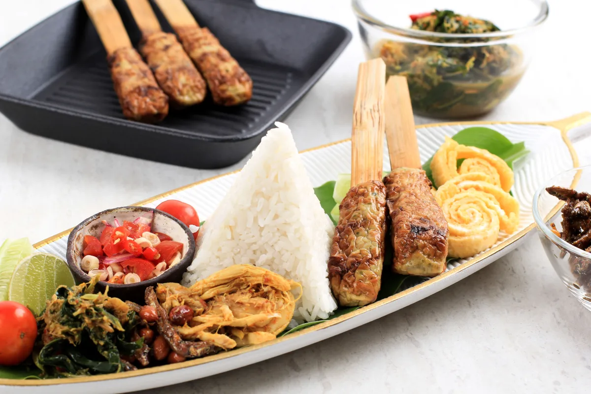 Traditional Balinese nasi campur with rice, sate lilit, vegetables, and sambal matah